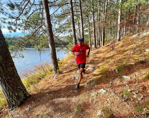 A trail runner on a lake trail for the Voyageurs Houseboat Tour