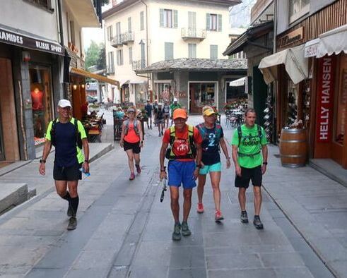 Group from a guided trail running experience enjoys a small town during the Tour du Mont Blanc trail running vacation
