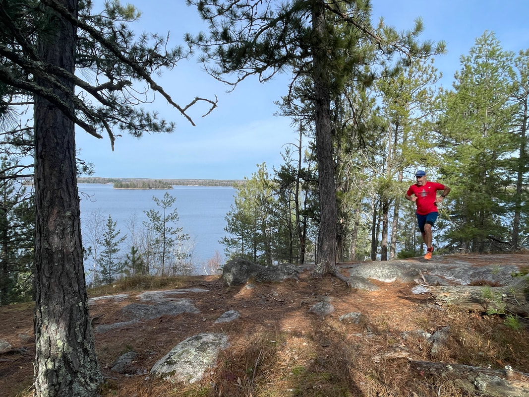 A trail runner on a lake trail for the Voyageurs Houseboat Tour
